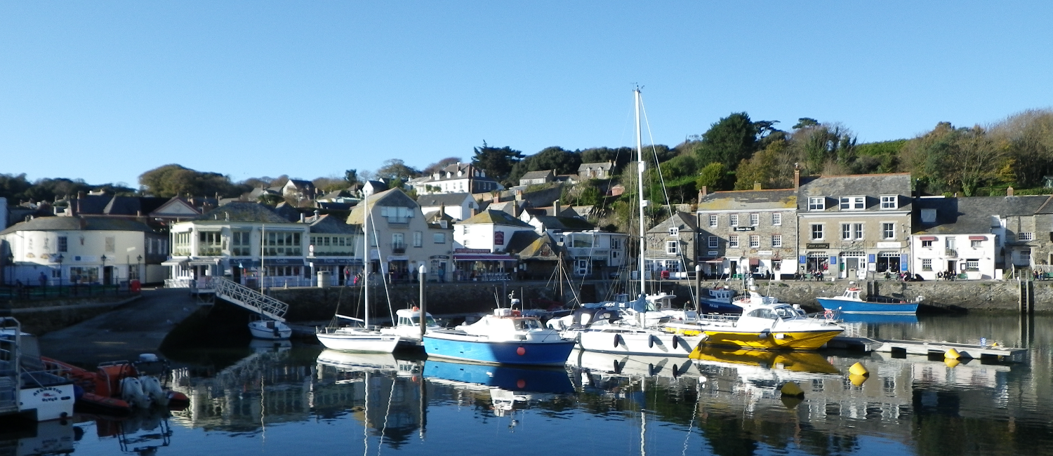 Boats tied up in the marina, reflective water, blue skies